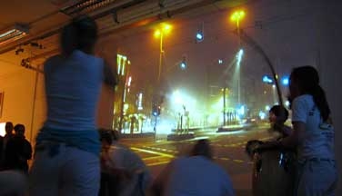 Capoeira Tanz vor dem Videobild einer Verkehrskreuzung bei Nacht