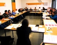 Das Bild zeigt Menschen in einem Seminarraum der FH, die gerade an einer Sitzung teilnehmen.