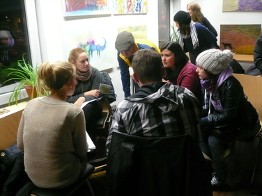 Auf dem Bild ist eine Gruppe Studierende zu sehen, in im Kreis sitzen und sich mit dem Thema Lebens- und Umweltgerechte STadt auseinandersetzten.