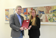 Das Bild zeigt den ehemaligen Dekan des Fachbereichs, Dr. Walter Eberlei, und die neue Dekanin, Dr. Elke Kruse, bei der symbolischen Übergabe des Amtes, ausgedrückt in Form eines roten Buches