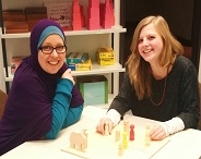  Zwei junge Frauen sitzen an einem Tisch.