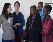 Studenten aus Deutschland und Afrika betrachten eine Flipchart.
